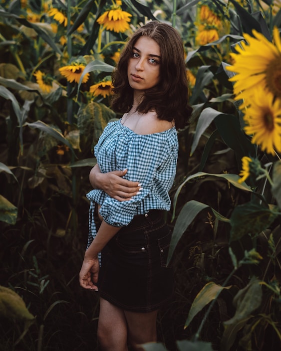 Young woman wearing casual clothes with sunflowers in background