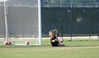 A defensive specialist diving to save a low ball during a competitive match.