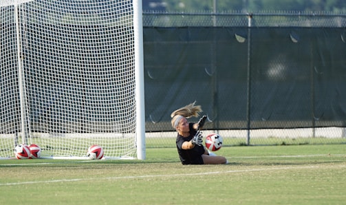 A defensive specialist diving to save a low ball during a competitive match.