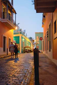 Historic cobblestone streets and vibrant buildings in Lisbon at golden hour.