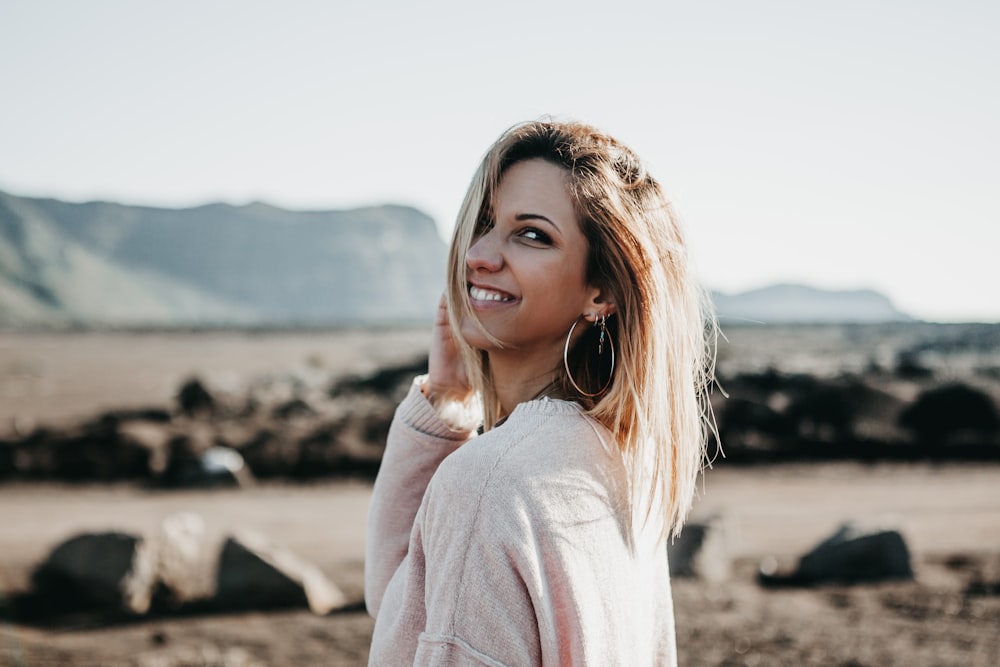 woman wearing sweater standing on beach shore