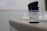 A container labeled 'Blood Glucose Test Strips' is placed on a surface. The label provides storage temperature information and details about the manufacturer. The focus is primarily on the container, with a blurred background.