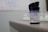 A container labeled 'Blood Glucose Test Strips' is placed on a surface. The label provides storage temperature information and details about the manufacturer. The focus is primarily on the container, with a blurred background.