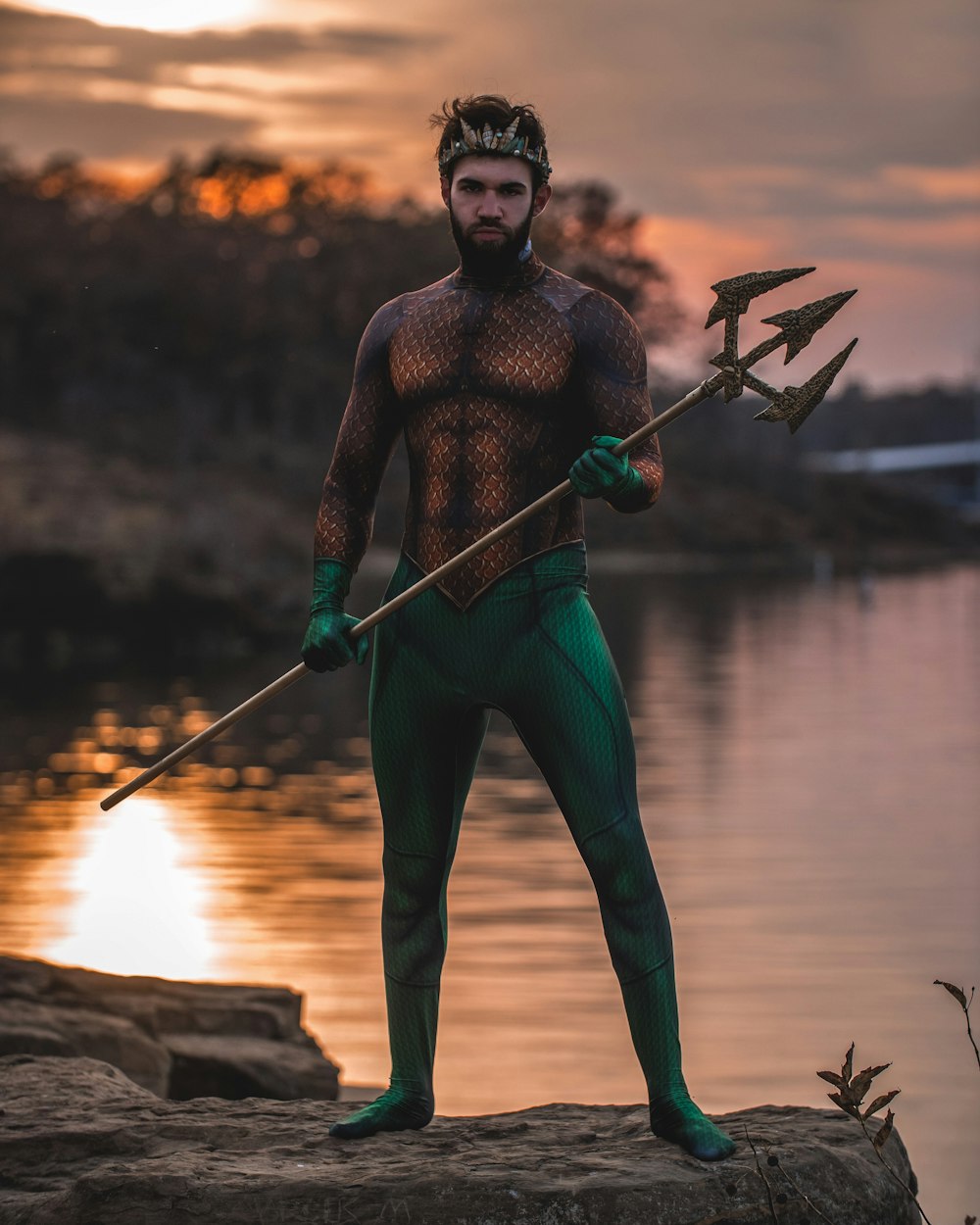 uomo che indossa il costume di Poseidone in piedi sulla roccia