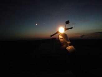 LED headlight upgrade glowing brightly on a vintage Siambretta scooter at dusk