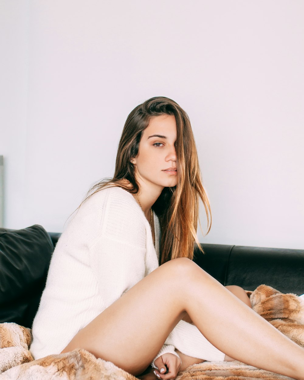 woman sitting on black and brown bed