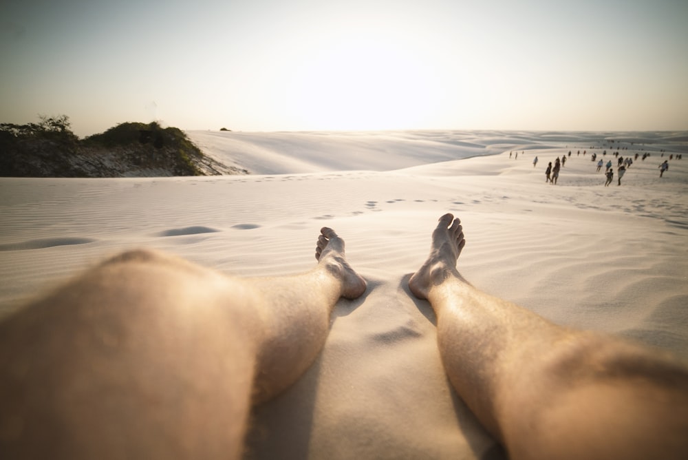 Vista de ángulo bajo de los pies de la persona sobre la arena