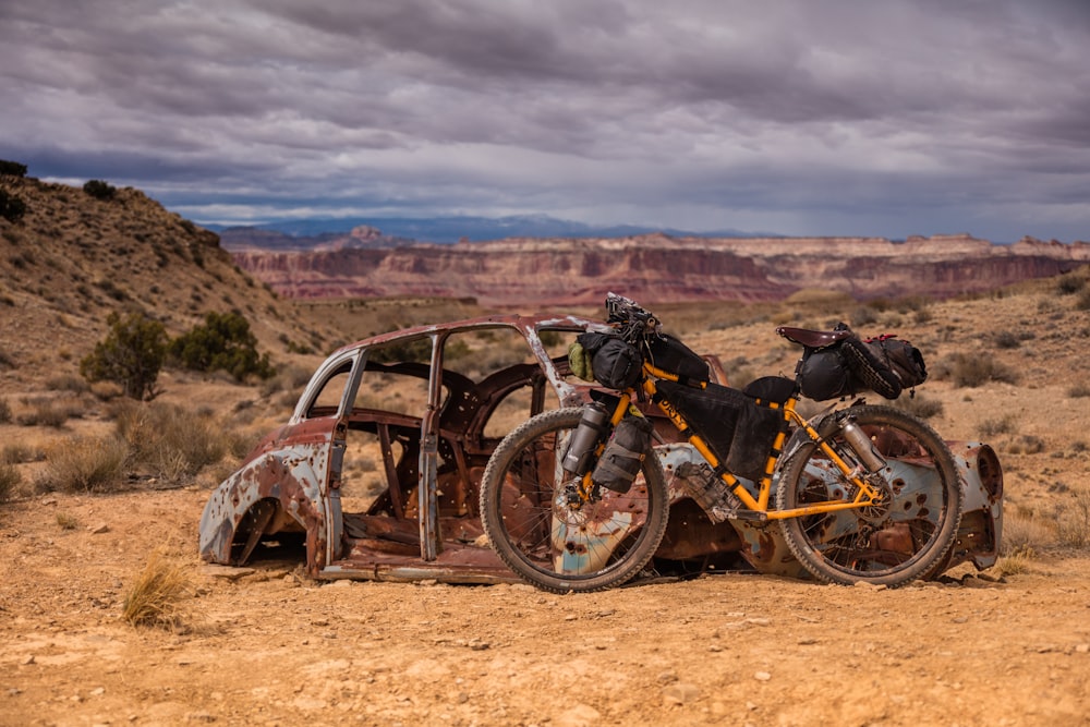 photo of yellow and black bicycle leaning on green Volkswagen beetle