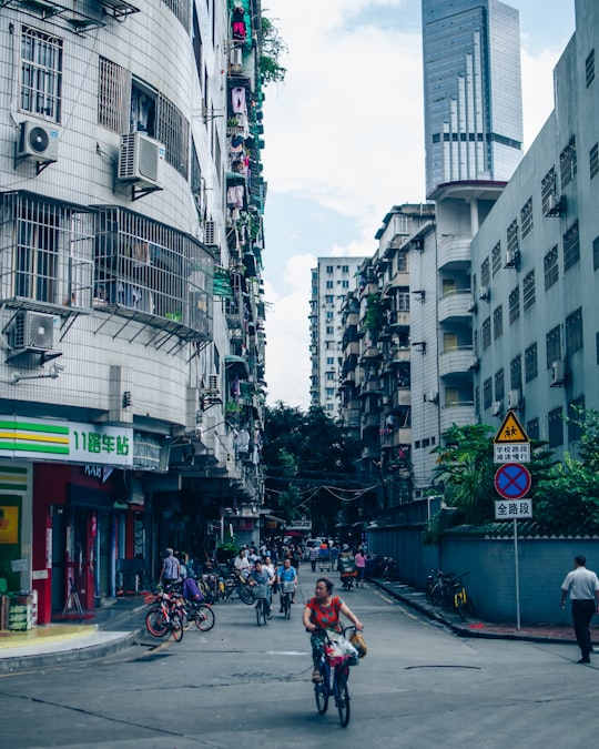 people walking and riding bicycles at the street in Guangzhou China