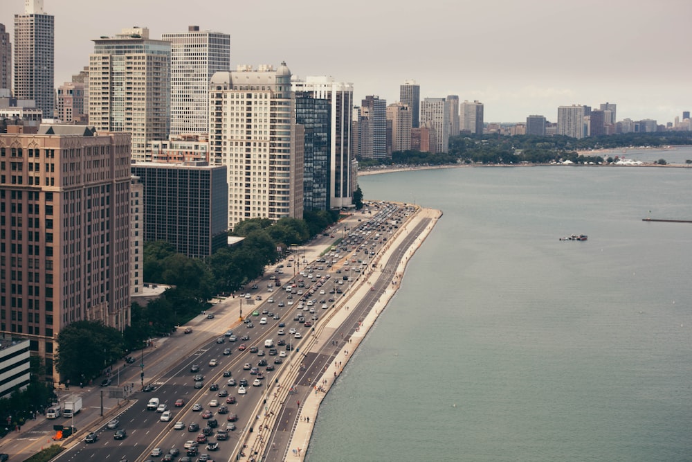 body of water beside buildings and road during daytime