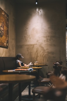 woman reading book inside coffee shop