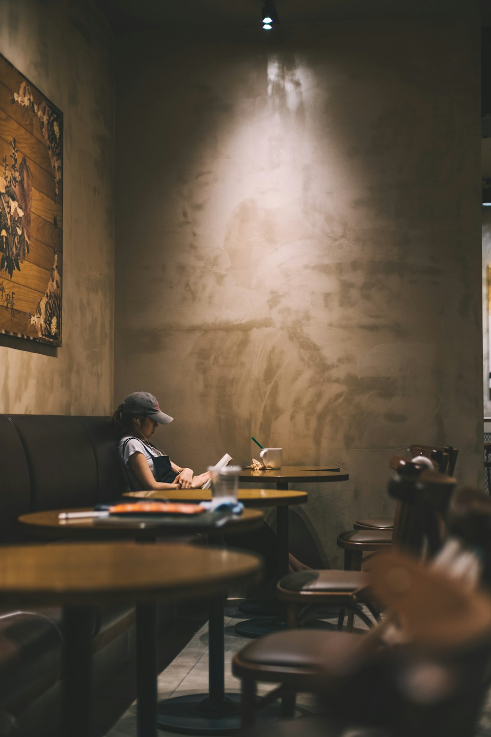 woman reading book inside coffee shop