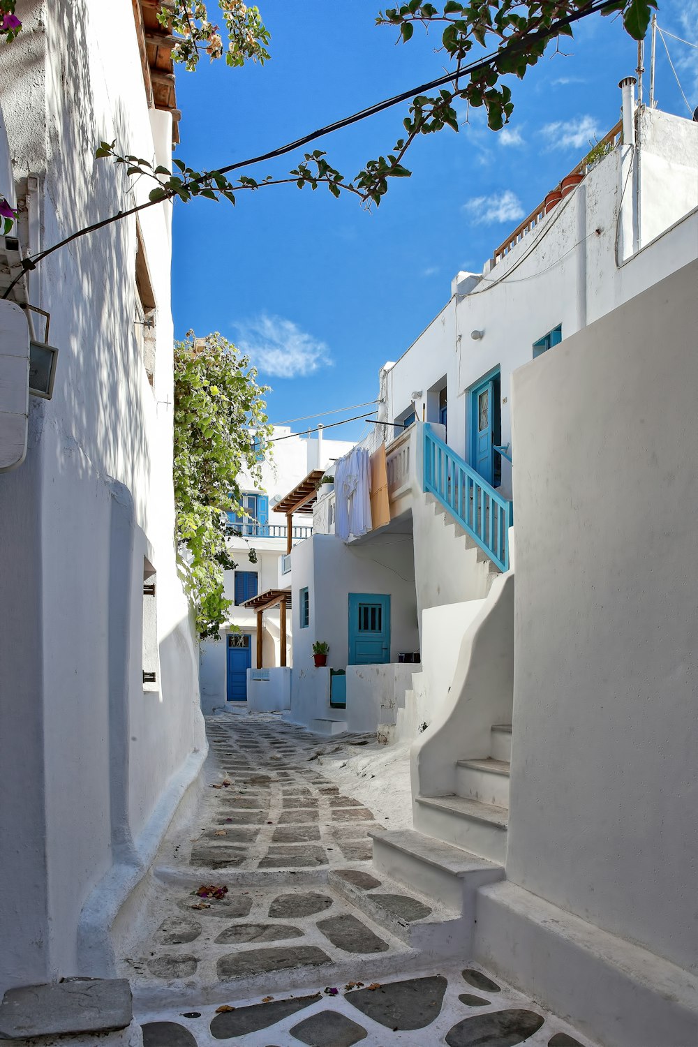 witte huizen met blauwe deuren en trappen