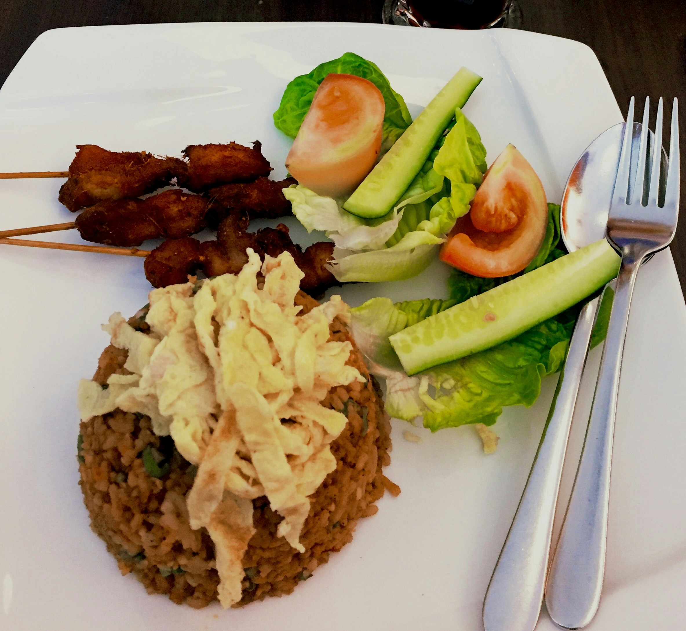 Pork BBQ rice meal with grilled skewers and steamed white rice on a plate