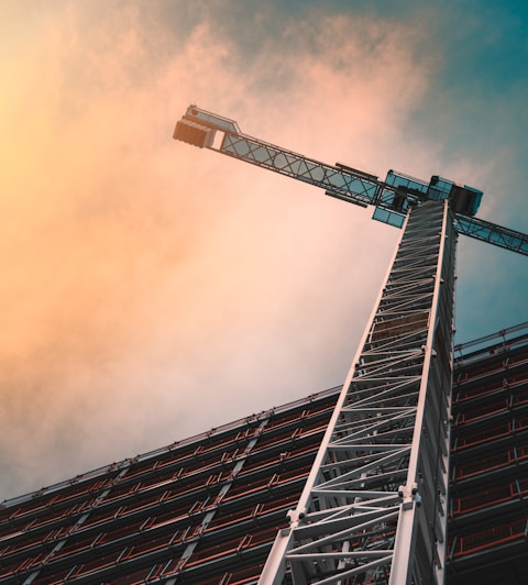 low angle photography of gray tower crane