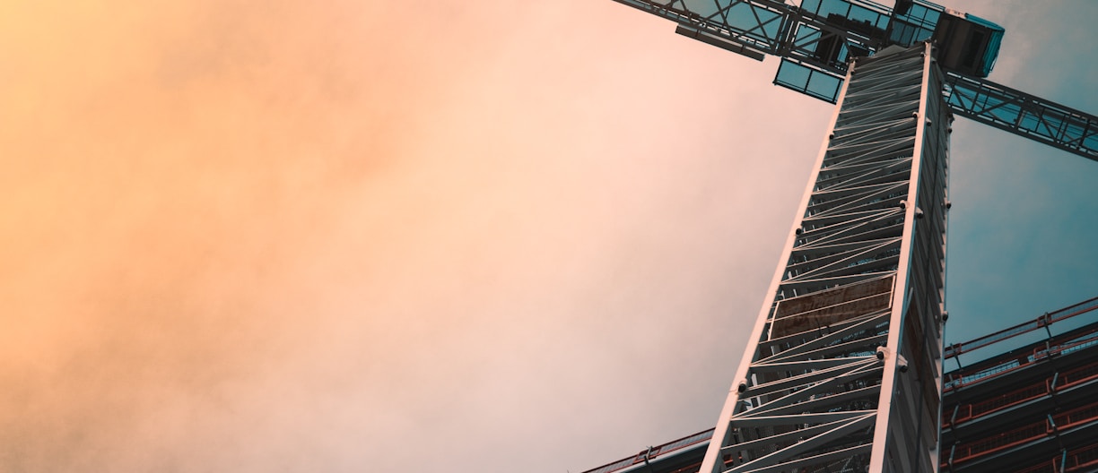 low angle photography of gray tower crane