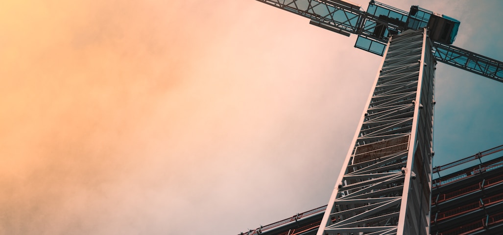 low angle photography of gray tower crane