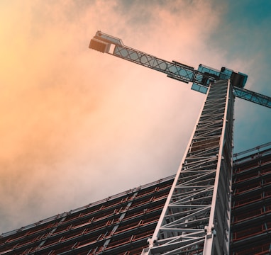 low angle photography of gray tower crane