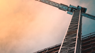 low angle photography of gray tower crane