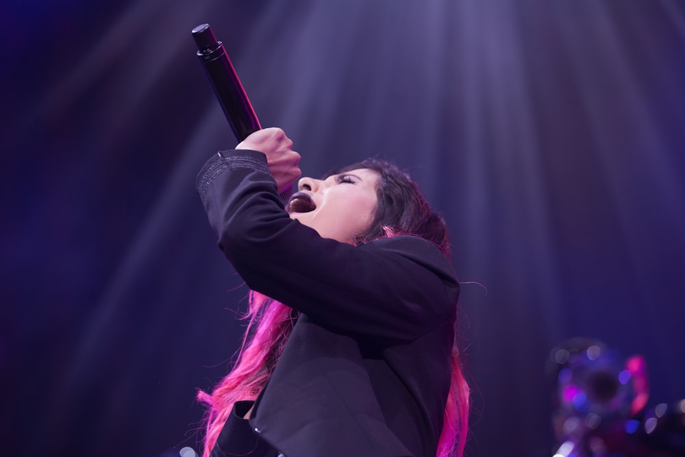 woman holding microphone while singing