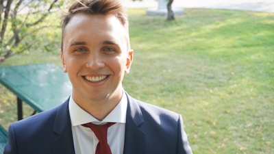 A smiling agent assisting a client outdoors in a sunny park.