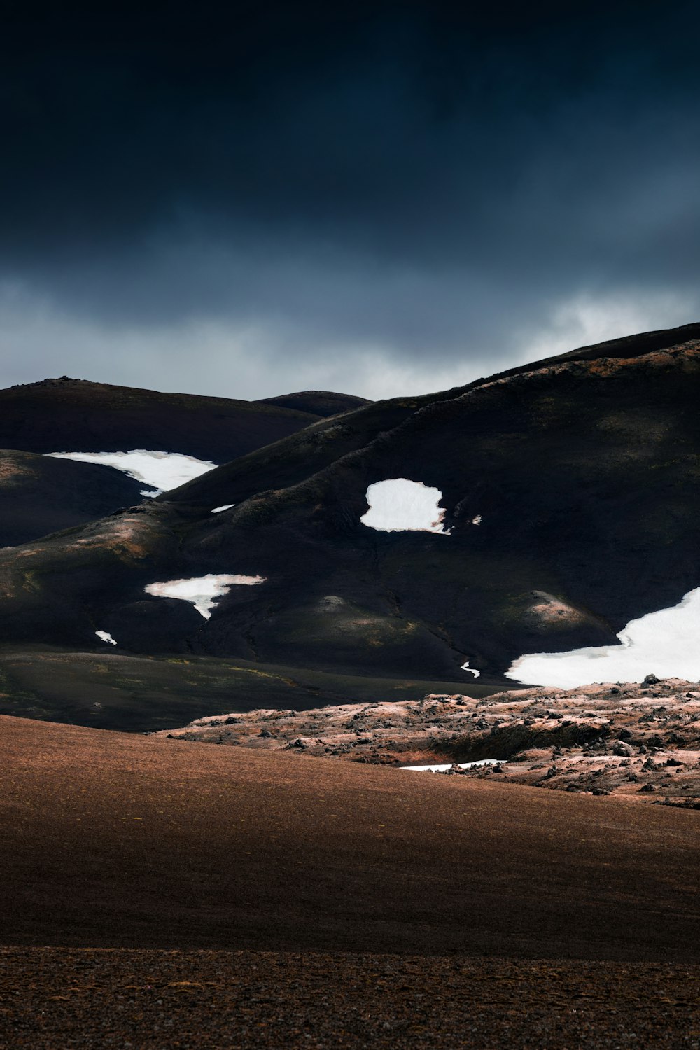 empty brown desert under gray sky rutting daytime