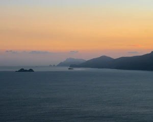 A serene coastal landscape with a travel influencer capturing the sunset.