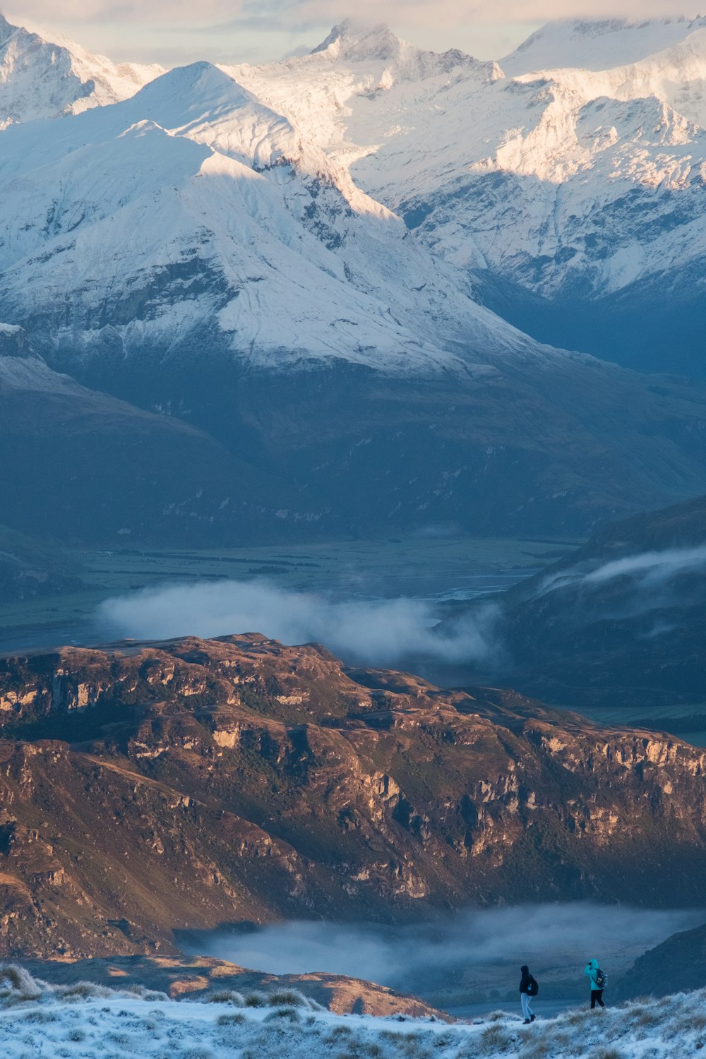 two person standing on mountain peak