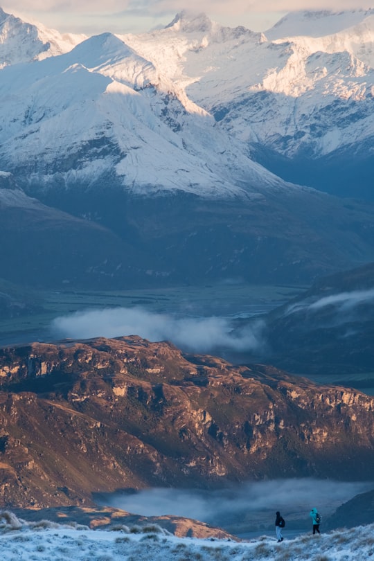 two person standing on mountain peak in Roys Peak New Zealand