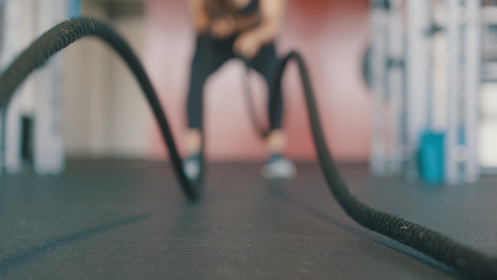 person holding black exercise rope