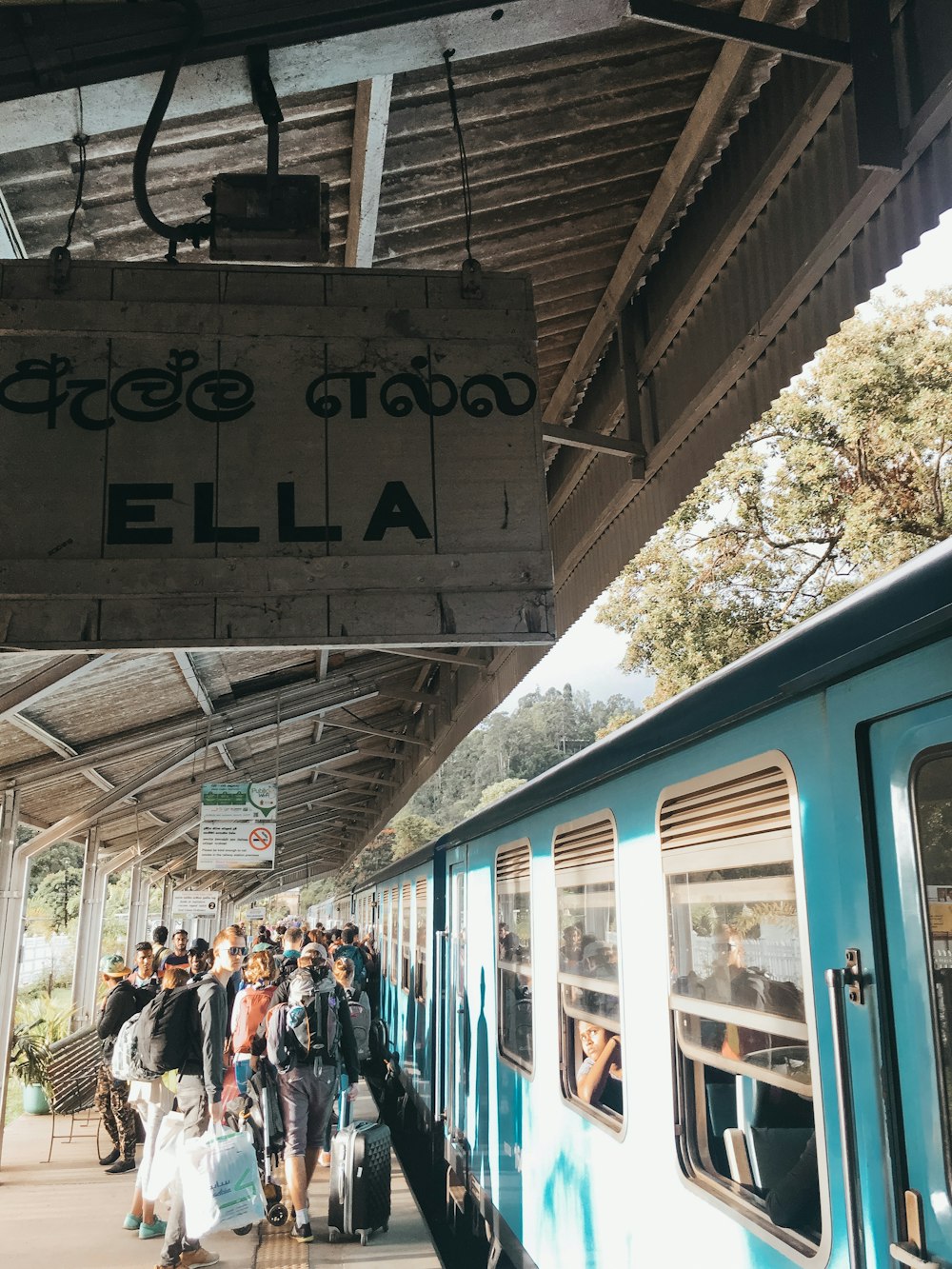 people standing beside teal train