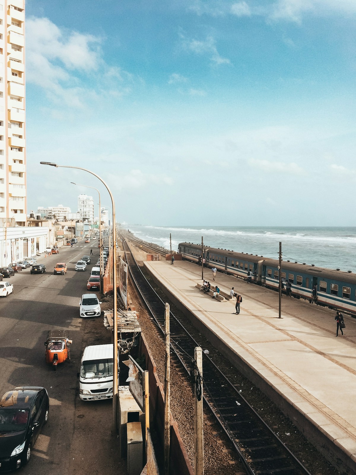 Colombo's coastal road alongside the railway line with tuk-tuks and vehicles in traffic - the city where Sri Lanka's smart metro bus network is now piloting