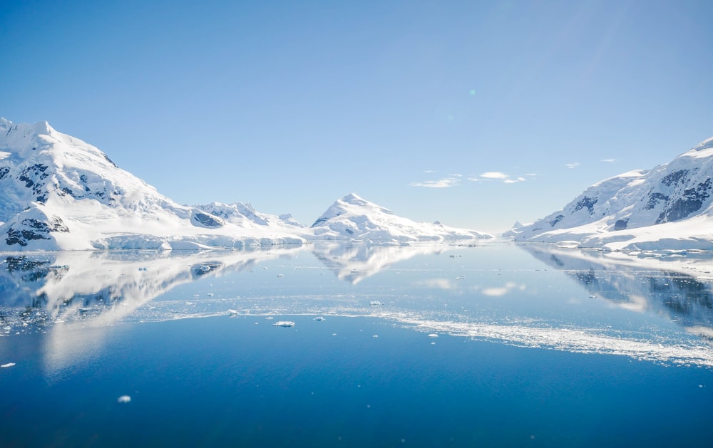 mountain with snow near body of water