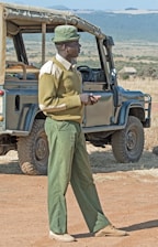 A professional driver in uniform ready beside a company vehicle