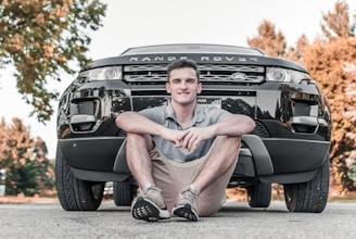 man wearing gray polo shirt in front of Range Rover car