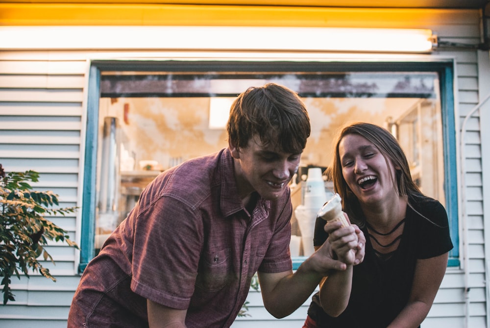 man and woman eating ice cream during daytime