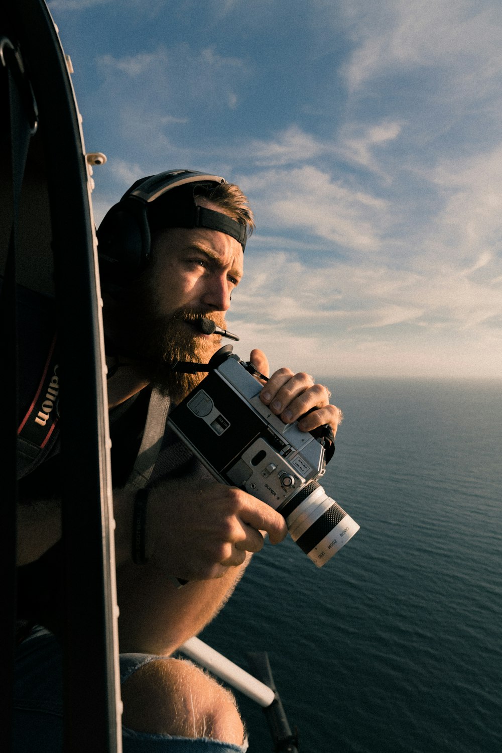 man riding on a helicopter with handycam during daytime