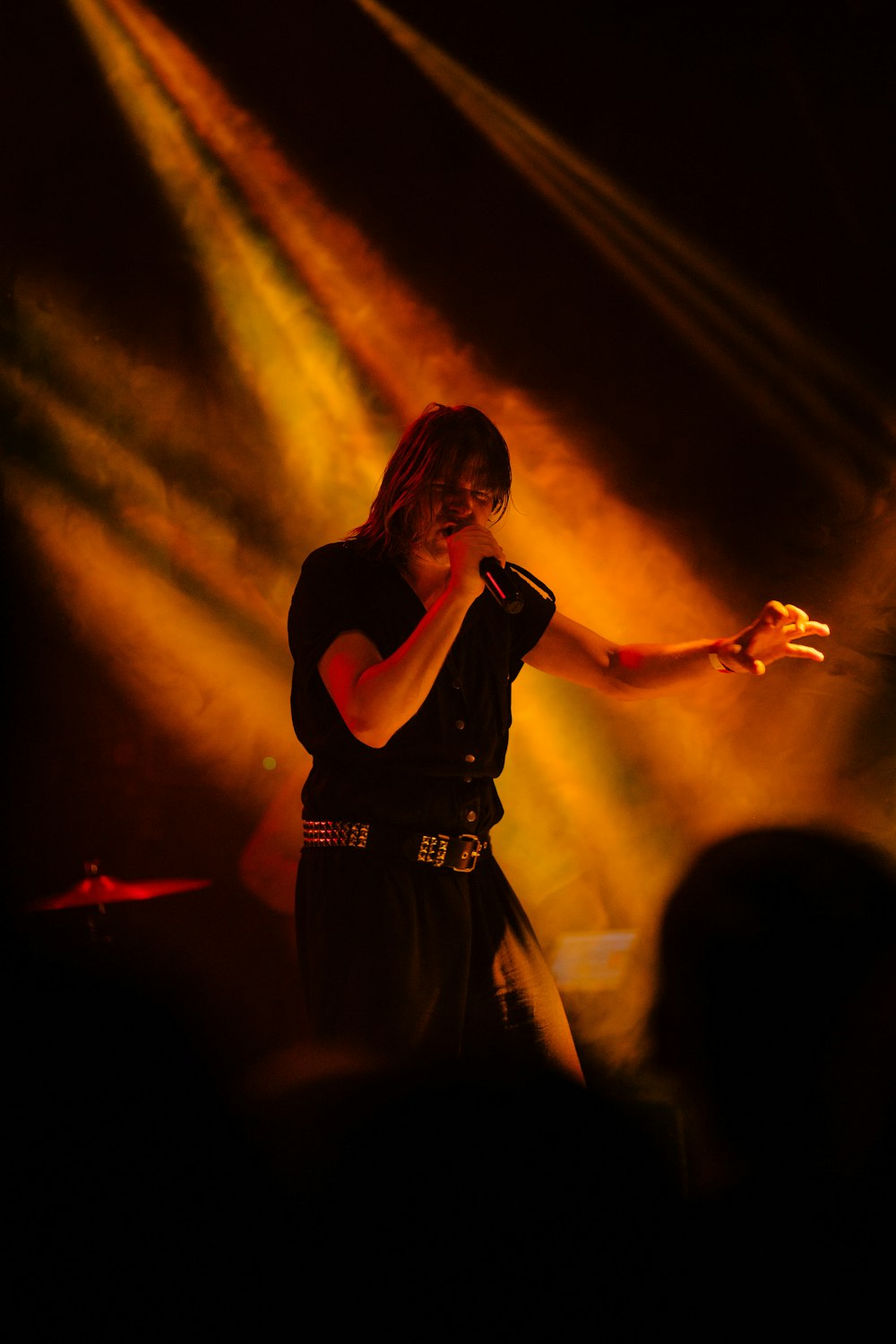 man holding microphone standing on stage with lightings