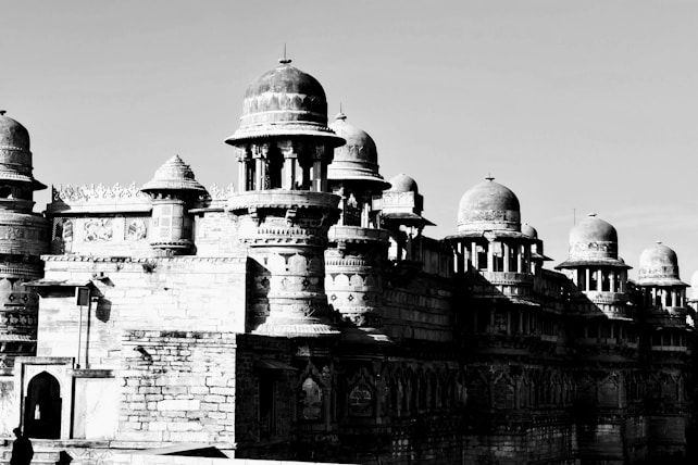 An ancient stone fortress with multiple domed towers and intricately carved details. The structure features elaborate patterns and designs typical of historical architecture.