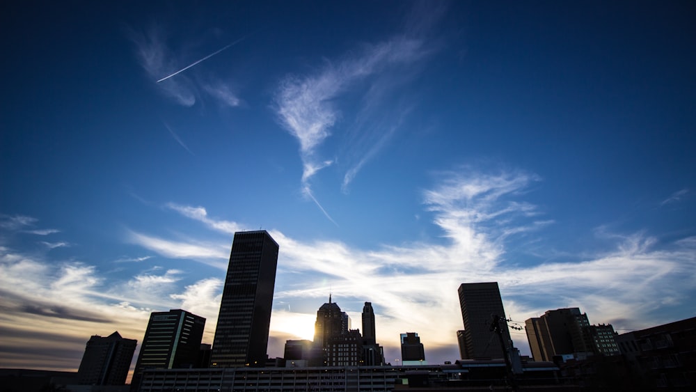 a view of a city skyline with a plane flying in the sky