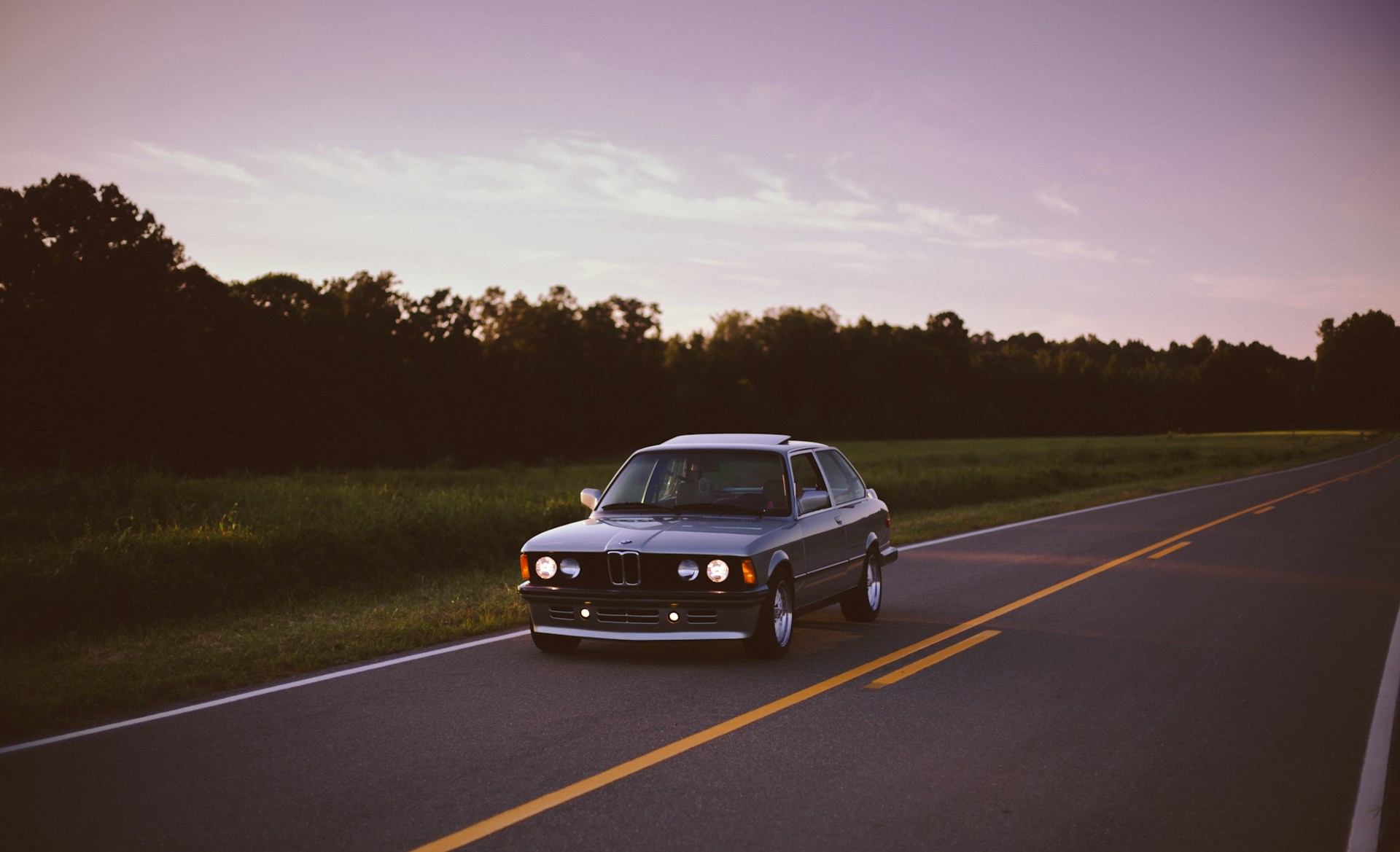 black sedan traveling on road