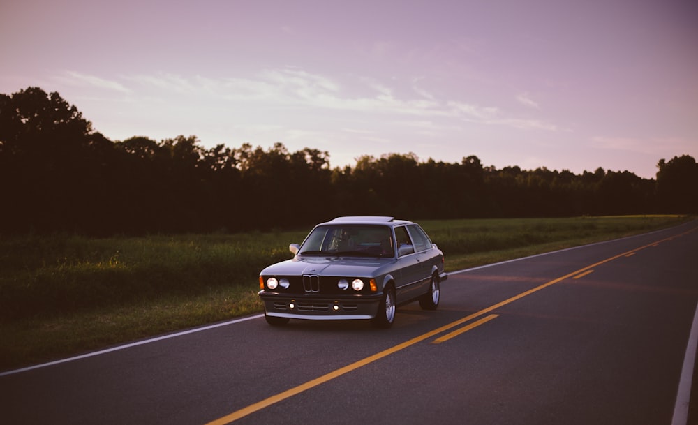 black sedan traveling on road