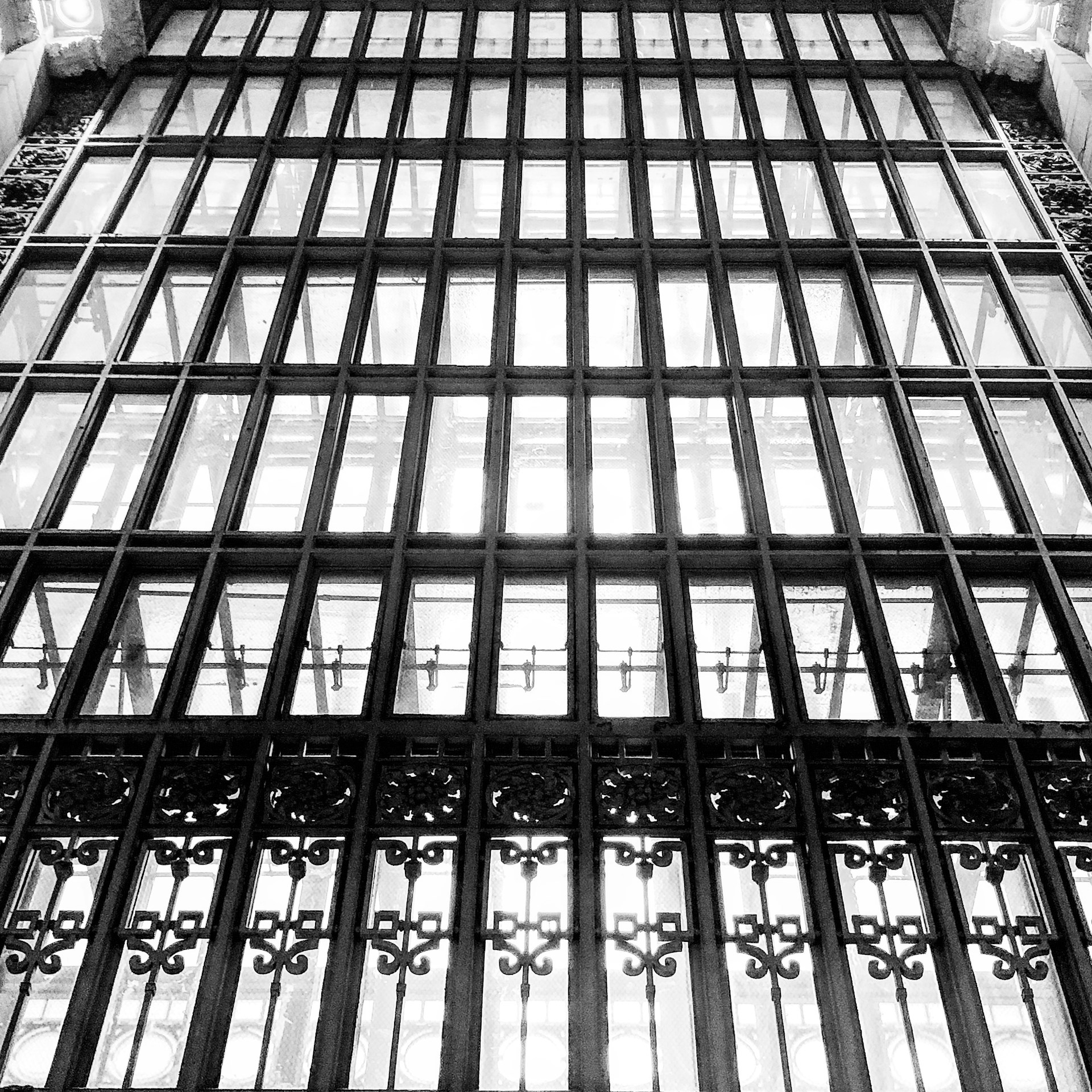 An intricate window art design featuring delicate silver accents and swirling shapes that catch the sunlight beautifully.