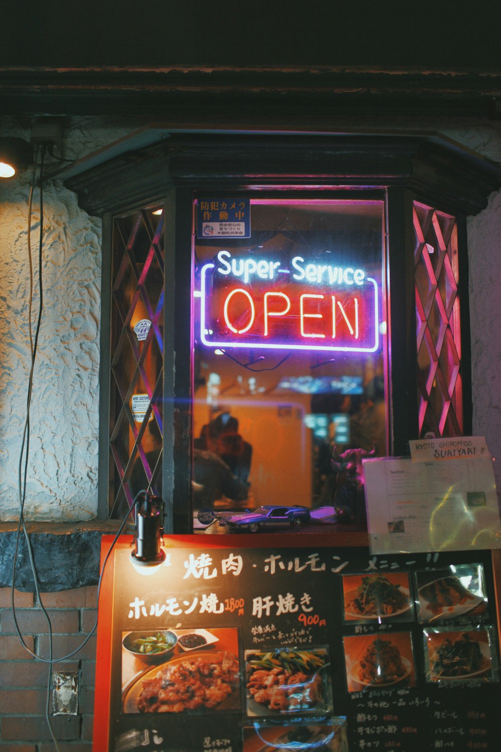 Super-Service open neon signage hanged on window