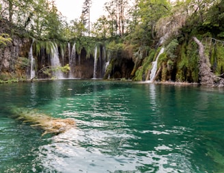 Crystal-clear waterfall cascading into a natural pool at a secluded resort