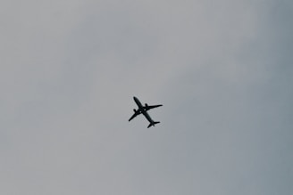 A minimalist illustration of a single traveler with a backpack looking at a plane taking off.