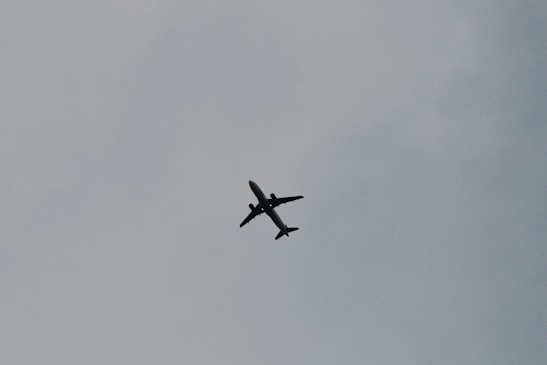 A minimalist illustration of a single traveler with a backpack looking at a plane taking off.