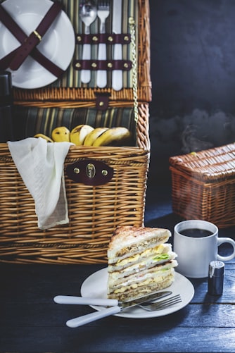 sandwich on plate beside brown wicker basket