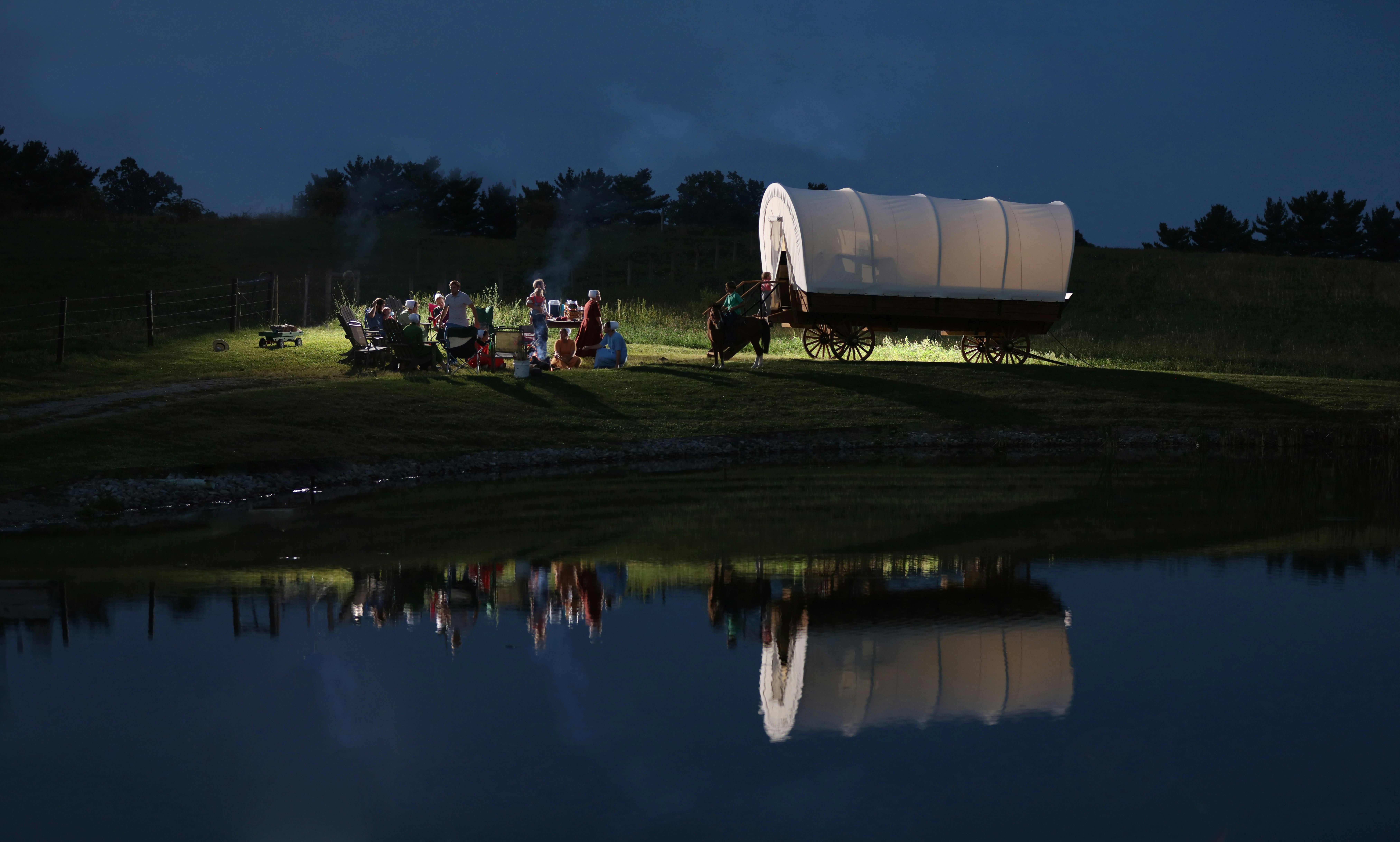 group of people near lake with white horse carriage, Night conestoga