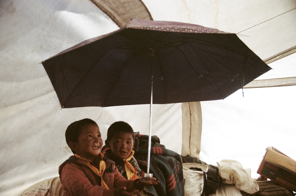 텐트에서 우산을 들고 있는 소년